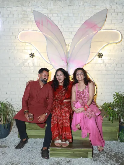 Guests enjoying our Navratri celebration, posing in front of our popular butterfly wing installation.