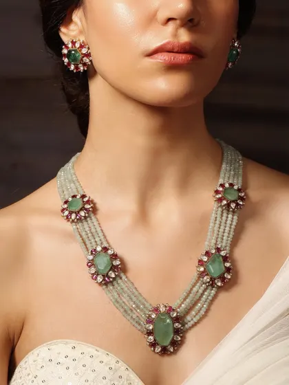 A beautiful long necklace from the Emrosia collection, with floral motifs of emerald and ruby set on strands of light green beads.