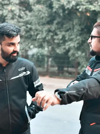 A moment of connection between two riders. This candid photo captures a handshake or a friendly gesture, emphasizing the brotherhood and camaraderie of the event.