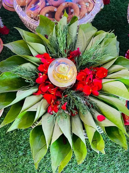 A beautiful aarathi plate made with betel leaves, fresh red flowers, and a divine centerpiece. This is a perfect addition to any puja or traditional welcoming ceremony.