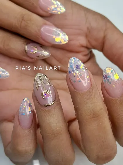 A modern bridal look with iridescent glitter flakes and a delicate gold chrome accent nail. It's perfect for the bride who wants something unique and chic.