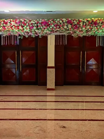 A wide view of the event space, showing how the floral arrangements and decor elements are used consistently throughout the venue to create a cohesive and immersive experience for guests.