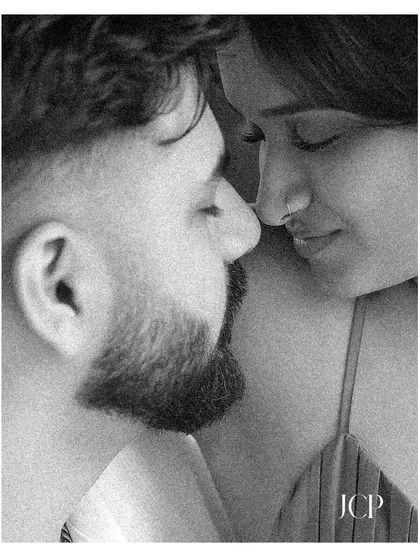 A grainy, black and white close-up, creating an artistic and emotional pre-wedding portrait.