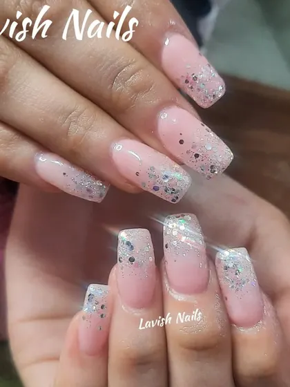 A classic glitter fade on long, square-shaped nails, with chunky silver glitter concentrated at the tips over a natural pink base.