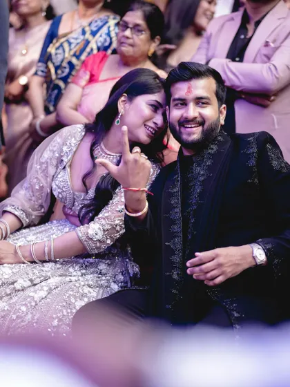 A fun, candid moment between the couple during their engagement ceremony, sharing a private joke.