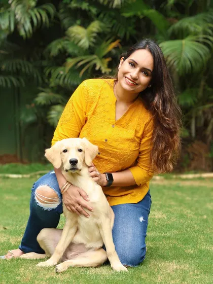 A lovely portrait of a dog mom and her sweet puppy. The lush green background of this outdoor setting makes their connection shine even brighter.