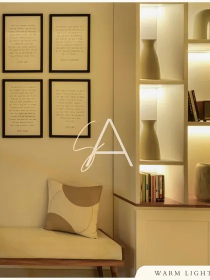 This reading nook combines function and style. The built-in shelving with integrated lighting highlights decorative objects, while the simple bench and framed art create a peaceful corner for relaxation.