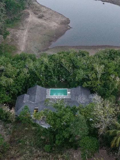 Aerial top-down views of The Leaf Poomala, revealing the U-shaped plan that wraps around a central pool and deck, creating a private sanctuary for guests.