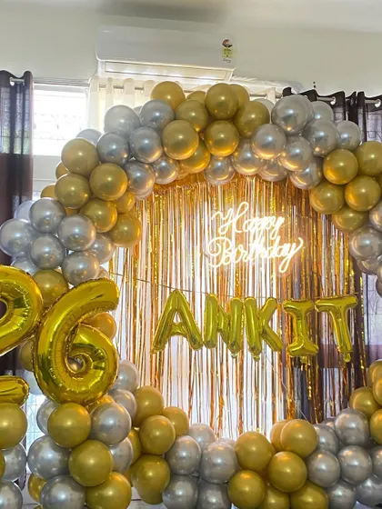 A stunning circular backdrop for Ankit's 26th birthday, featuring a gold and silver balloon ring, a gold fringe curtain, and personalized foil balloons.