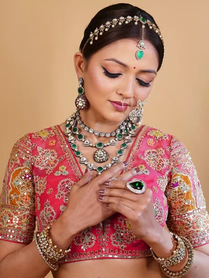 A close-up on the details. The makeup is kept elegant and understated to allow the magnificent, layered jewellery to take center stage.