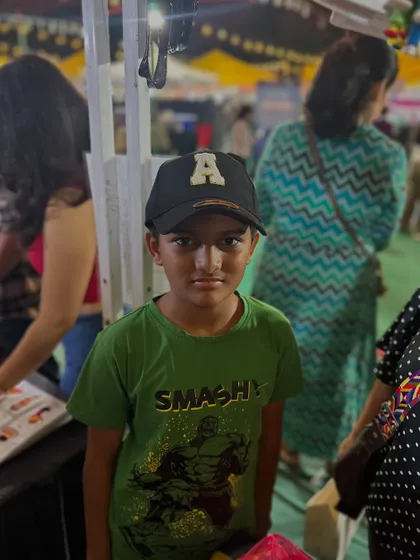 A young boy showing off his new custom cap at my event stall.