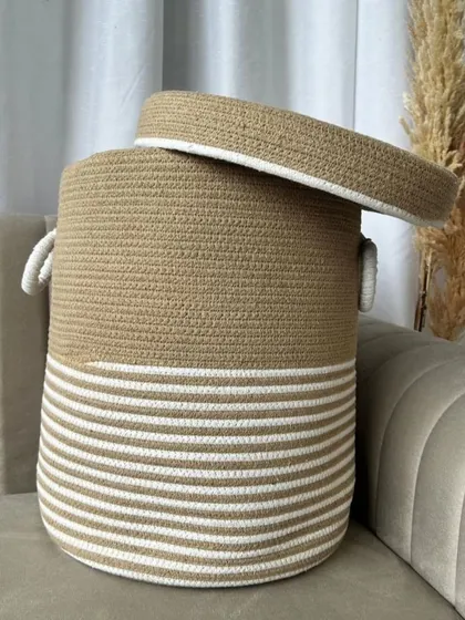 A beautiful beige and white striped rope basket with a lid. The neutral colors and clean design make it a perfect fit for modern and minimalist homes.