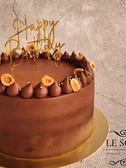 A classic and elegant chocolate cake. This 1 kg Chocolate Hazelnut cake has a smooth ganache finish and is simply decorated with toasted hazelnuts and a birthday topper.