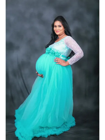 This unique cyanish-green maternity gown features delicate white lace sleeves for a touch of elegance. The full-sleeved design offers more coverage while still beautifully highlighting the baby bump.