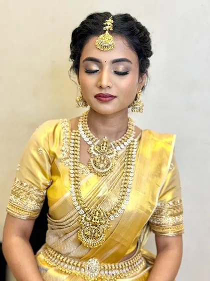 The eye makeup for this muhurtham look features soft, shimmery golds and a defined lash line, making the eyes stand out beautifully.