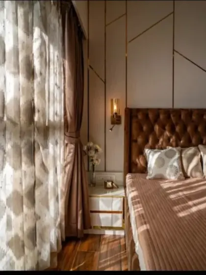 The play of natural light can transform a room. Here, sunlight streams through sheer curtains, highlighting the textures of the bedding and the geometric pattern on the accent wall, creating a serene and peaceful morning ambiance.