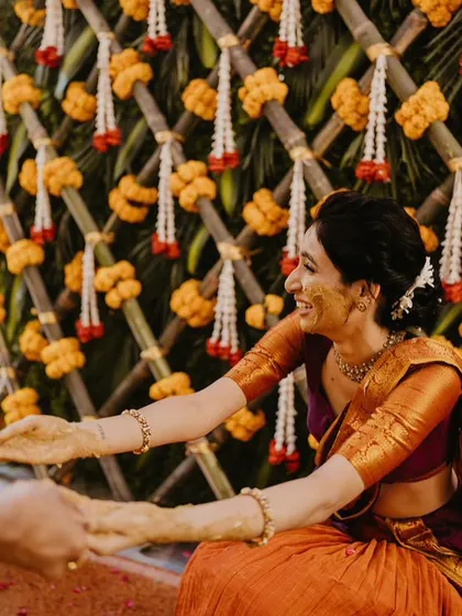 A candid moment from a Haldi ceremony, capturing the bride's infectious smile.