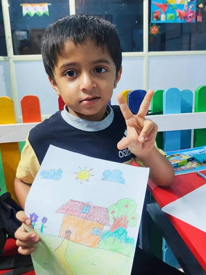 This student is celebrating his first day of art class with a fantastic and colorful drawing of a house.
