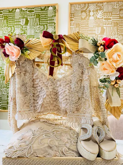 An ethereal ivory outfit paired with sparkling heels. The arrangement is accented with gold fans and soft florals for a touch of romantic glamour.