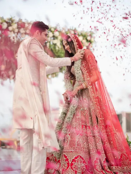 This is the moment it all begins. We capture the pure joy of the Varmala ceremony, with a shower of petals celebrating the union. It's a frame filled with energy, color, and the promise of a beautiful forever.