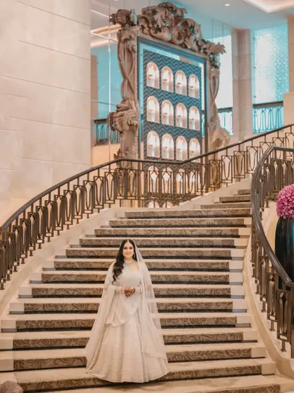 A vision in white. The bride poses on the magnificent staircase of the St. Regis, looking every bit like a queen.