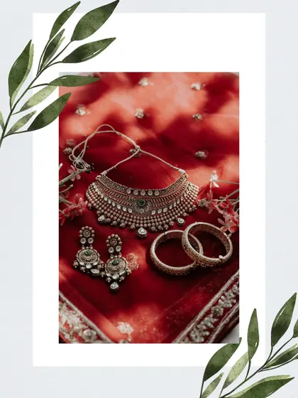 A flat-lay of the bridal jewelry. This artistic shot showcases the intricate design of the necklace, earrings, and bangles against the rich red of the bride's dupatta.