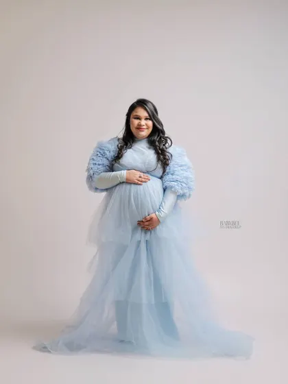 Feel like a queen in one of our ethereal tulle gowns. This portrait highlights the elegance and grace of pregnancy, using soft studio lighting to create a bright and airy feel.