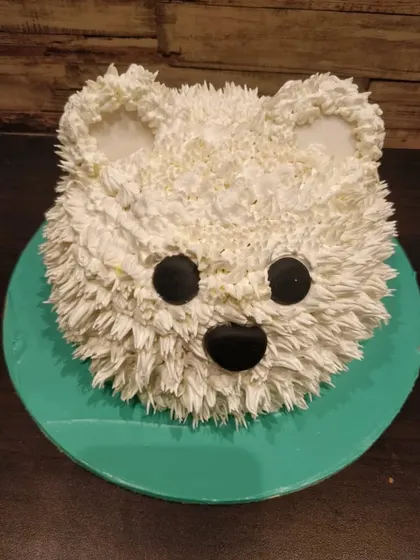 A cute and fluffy 3D teddy bear head cake. The fur texture is created with piped buttercream, making it as delightful to look at as it is to eat.