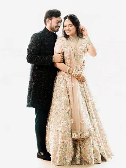 A classic and elegant high-key studio portrait. The all-white background makes the couple and their beautiful floral outfits pop, creating a fresh and timeless image.