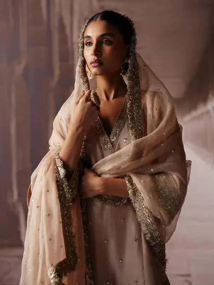 A close-up portrait capturing the soft, ethereal quality of a sheer dupatta. The styling focuses on creating a gentle and romantic mood, perfect for a bridal lookbook.
