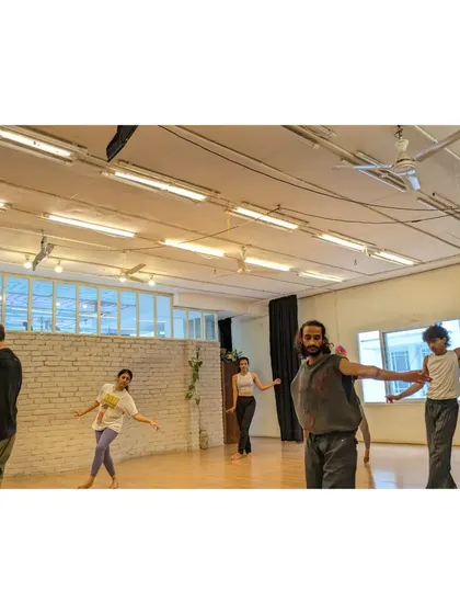 Dancers work on a partner exercise, focusing on connection and shared movement.