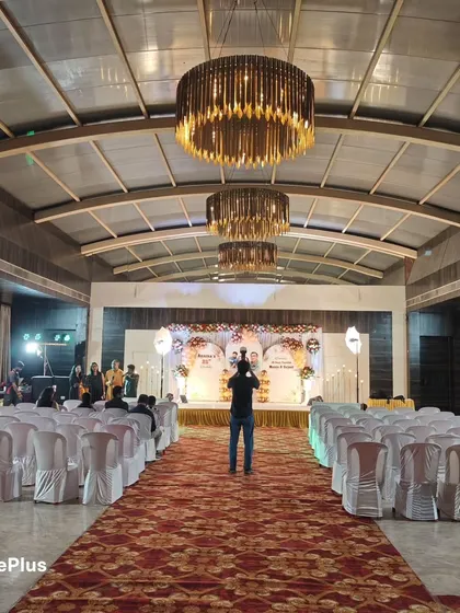 A wide view of the hall for the 25th birthday celebration. The chandeliers and spacious seating arrangement show that this venue is perfect for a large gathering.