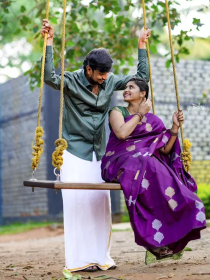 A playful and sweet photo of a couple on a swing, dressed in traditional attire. This combines tradition with a touch of modern fun.