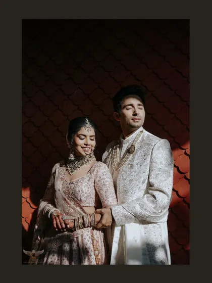We are chasers of that perfect light. Here, the golden hour sun casts dramatic shadows, highlighting the couple's serene connection and the intricate details of their wedding attire in a shot that feels like a page from a magazine.