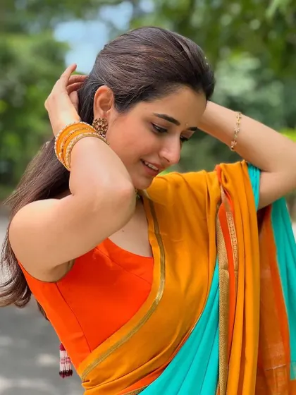 A candid shot of Ashika. The simple, clean lines of the sleeveless blouse make it a versatile piece that lets the saree be the hero.