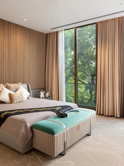 The master suite in our Punjabi Bagh project is a sanctuary designed for slow, luxe living. Expansive floor-to-ceiling windows invite the surrounding greenery indoors, while a fluted feature wall and understated materials create a serene, textural backdrop for rest and relaxation.
