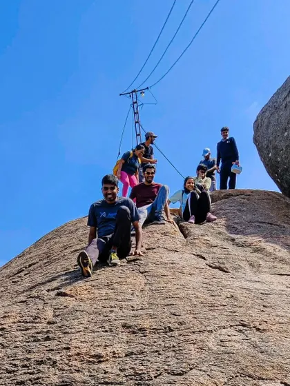 A team enjoying a fun, natural slide on the rocks of Nijagal Betta, a perfect example of playful team bonding.