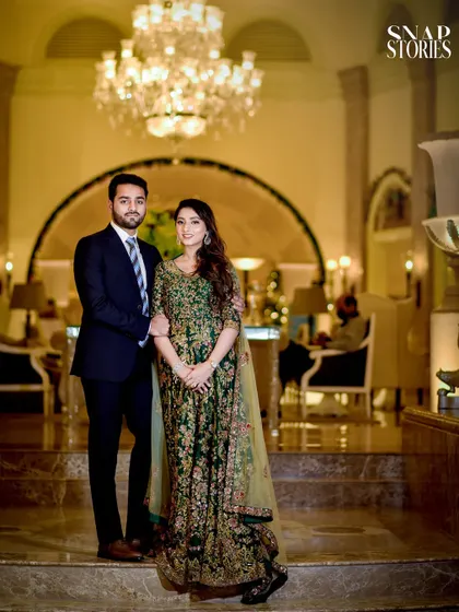 A classic portrait of the couple in formal attire, standing in the opulent lobby of a luxury hotel, perfect for an elegant and sophisticated pre-wedding shoot.