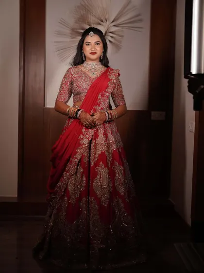 The full look, a picture of modern bridal elegance. The red lehenga is a classic choice, and the makeup is perfectly matched.