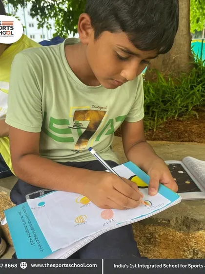 A student works on his notebook outdoors, showing how we make learning a comfortable and inspiring experience.
