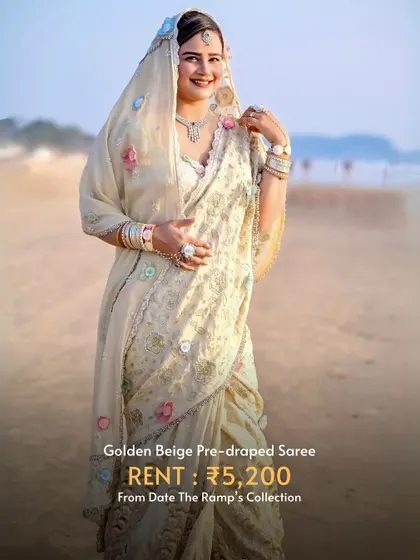 A beautiful golden beige pre-draped saree, perfect for a beach wedding or a daytime festive event.