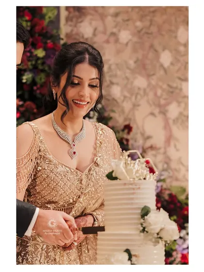 Shravya cutting her reception cake, looking absolutely beautiful. The makeup is designed to be long lasting and photo ready, ensuring she looks perfect through all the special moments of her big day.