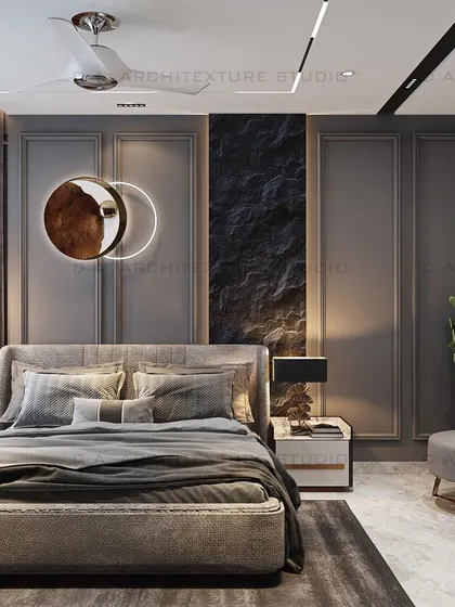 A bedroom design for our Meera Bagh project, featuring a textured stone panel behind the bed, flanked by grey wall molding and contemporary lighting.