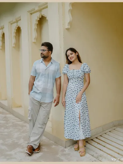 A stylishly posed shot against a yellow wall with architectural details, capturing a relaxed yet chic vibe in Udaipur.