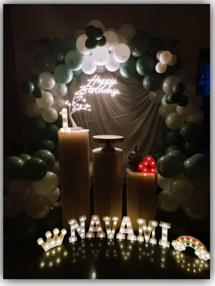 For Navami's birthday, we went with a simple yet elegant green and white color scheme. The balloon arch, neon sign, and personalized marquee letters created a beautiful focal point for the celebration.