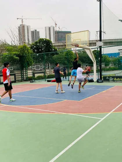 A player goes up for a rebound amongst a crowd of teammates and opponents.