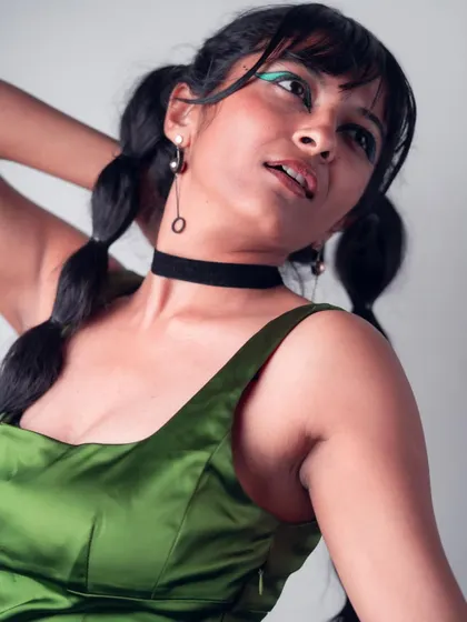 A candid, upward-looking pose from the 'Art in Motion' series. This shot captures a natural and expressive moment, highlighting the creative makeup and hairstyle.