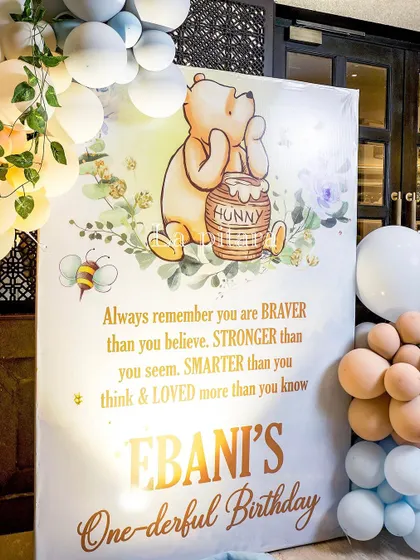 A heartwarming welcome sign for 'Ebani's One-derful Birthday', featuring a classic Pooh illustration and an inspiring quote.