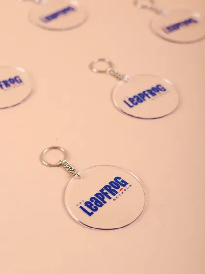 Custom acrylic keychains featuring The Leapfrog Network's branding. It's the little details that make a welcome kit feel complete.