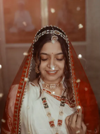 A dreamy portrait of a Bengali bride, her face gently illuminated by fairy lights, creating a soft and magical glow.